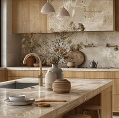 a kitchen with marble counter tops and wooden cabinets, along with hanging lights above the sink