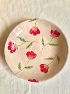 a white plate with red flowers painted on it