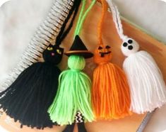 three tasseled halloween decorations on a notebook