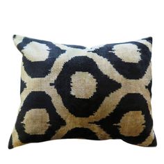 a black and gold pillow with circles on it, against a white background the pillow is made out of an overstuffed fabric