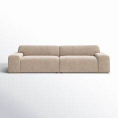 a beige couch sitting on top of a white floor