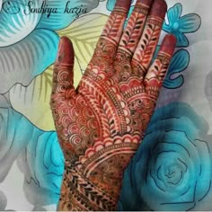 a hand with henna on it and flowers in the backgroung background