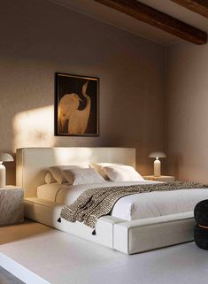 a bedroom with a large bed and two lamps on the nightstands next to it