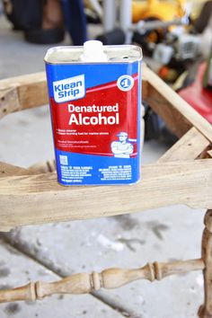 a can of alcohol sitting on top of a wooden chair