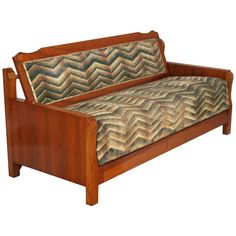 a wooden couch with an upholstered design on it's armrests