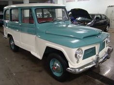 an old blue and white truck parked in a garage