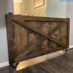 a wooden gate with wheels on the floor in front of a door that says dark walnut