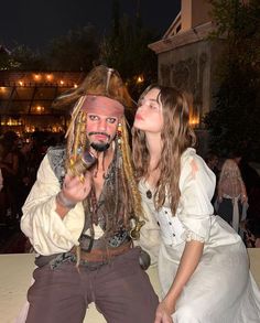 two people dressed as pirates pose for a photo