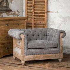 an old chair sitting on top of a wooden floor next to a dresser and mirror