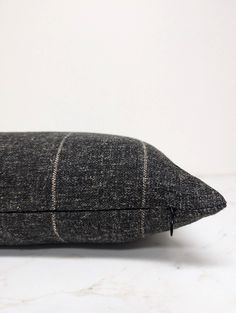 a black and white pillow sitting on top of a table