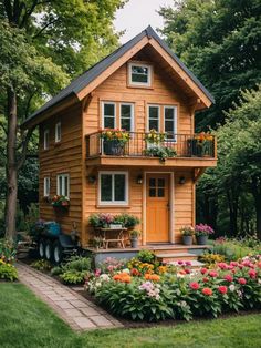 a small wooden house surrounded by flowers and trees