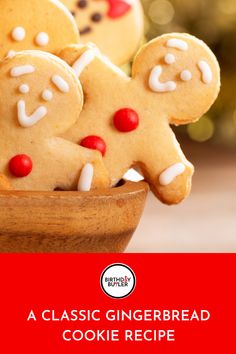 gingerbread cookies in a wooden bowl with white icing and red candies on top