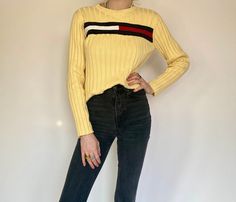 "Product Details: Gorgeous vintage pastel light yellow ribbed pullover by Tommy Hilfiger. Long sleeve and ribbed, this cozy sweater is perfect for every occasion. Has TH logo across chest of sweater. Pair it with black jeans. Has stretch. Brand: Tommy Hilfiger Material: 100% Cotton Marked Size: L Measurements: Waist: 18.5\" Length: 22\" Neck Drop: 2.5\" Amazing condition. Model: 5'9\" All sales are final." Yellow Ribbed Long Sleeve Top, Spring Yellow Ribbed Sweater, Th Logo, Tommy Hilfiger Long Sleeve, Pullover Outfit, Pullover Sweater Women, Pastel Yellow, Cozy Sweater, Ribbed Sweater