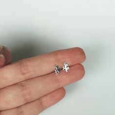 A PAIR of tiny sterling silver leaves on a stem sear studs. Size: 5 x 7 mm These earrings are made of 925 hypoallergenic sterling silver. All my pieces are sent in a gift box. I can include a personal message from you if needed. You are welcome to contact me at... bhavnakwintra1956@gmail.com More hoops: https://www.etsy.com/your/shops/TheSilverGame/tools/listings/section:26305414 More earrings: https://www.etsy.com/your/shops/TheSilverGame/tools/listings/section:26308789 Ear climbers: https://ww Silver Leaf Minimalist Earrings, Minimalist Silver Leaf Earrings, Silver Leaf-shaped Minimalist Earrings, Dainty Tiny Silver Cartilage Earrings, Dainty Small Silver Earrings, Simple Tiny Silver Cartilage Earrings, Simple Sterling Silver Cartilage Earrings Gift, Delicate Nickel Free Silver Cartilage Earrings, Delicate Nickel-free Silver Cartilage Earrings