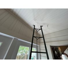 a tall metal ladder sitting in the middle of a room next to a door and window