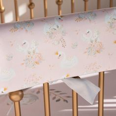 a baby crib with pink and gold bedding