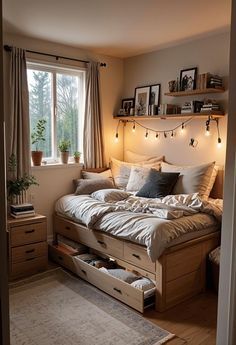 a bed sitting under a window in a bedroom next to a wooden dresser and drawers