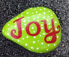 a green rock with the word joy painted on it