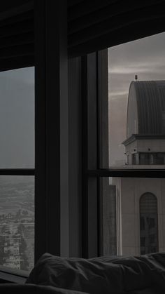 a view out the window of a building with a clock tower in the distance