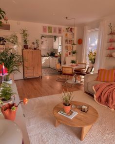 a living room filled with furniture and lots of plants on top of a wooden table