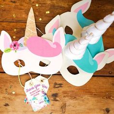 a unicorn mask with a tag hanging from it's side on a wooden table