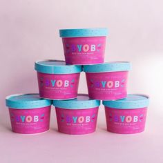 six yogurt cups are stacked on top of each other in pink and blue