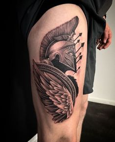 a man's leg with an eagle and helmet tattoo on the side of his thigh