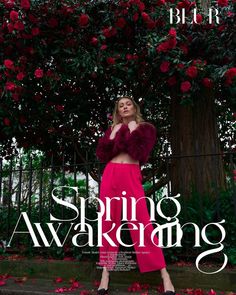 a woman standing in front of a tree with red flowers on it and the words spring awake