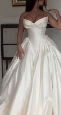 a woman in a white wedding dress posing for the camera