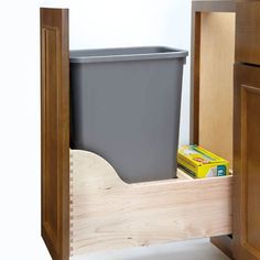 a trash can sitting in the corner of a cabinet