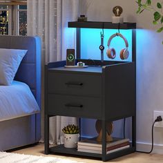 a night stand with headphones on it next to a bed and a plant in the corner