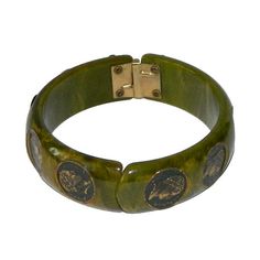 "Item: This is a spinach green bakelite clamper bangle with some nice marbling and little coins inset encircling the bracelet. The hinge works fine and I don't see any major scratching or chips. Tested and guaranteed vintage bakelite. Be sure to check our other listings for lots more bakelite jewelry! Measurements: 3/4\" wide - 2 1/2\" inner diameter, about 7 3/8\" inner circumference. Condition: 9 - Very good, slightly misaligned, otherwise in excellent condition. Shipping: Shipping in the U.S. Green Vintage Cuff Bracelet, Vintage Green Cuff Bracelet For Formal Events, Vintage Green Cuff Bracelet For Formal Occasions, Vintage Green Bangle Jewelry, Green Vintage Cuff Bracelet For Formal Occasions, Green Vintage Formal Cuff Bracelet, Vintage Bakelite Bangle Jewelry, Vintage Bakelite Bangle, Vintage Green Adjustable Cuff Bracelet