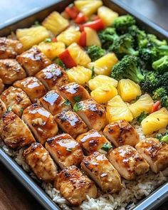 chicken and pineapple kabobs served on rice with broccoli