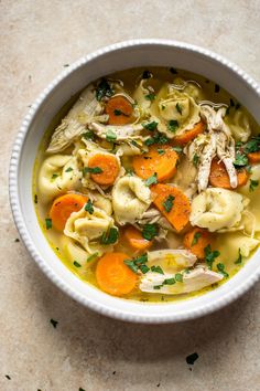 a white bowl filled with chicken tortellini soup