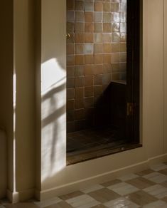 an empty bathroom with tiled walls and flooring in the sun shining through the window