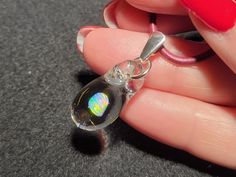 "Dive into the depths of the ocean with my dainty Mermaid's Tears pendant! This gorgeous small hand-blown teardrop pendant is made with only the highest quality borosilicate glass and features a mesmerizing Gilson opal polished nugget that shimmers with blue, green, yellow, orange and even a hint of red within the opal encased in glass. I carefully hand blow each pendant by melting the glass tubing with the Gilson opal inside within a bubble at the end.  I then condense the bubble to a solid form into the  perfect teardrop shape. This must be done slowly to completely encase the  Gilson opal within the glass to create a stunning, one-of-a-kind piece that's truly unique. The tiny boro pendant measures .8\" x .4\"  but with the bail the whole pendant dangles 1.2\".  This petite  pendant come Silver Opal Drop Jewelry, Opal Choker, Art Glass Jewelry, Mermaid Tears, Choker Pendant, Necklace Design, Color Tones, Teardrop Pendant, Opal Necklace