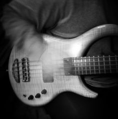 a person is playing an electric guitar in black and white photo with blurry background