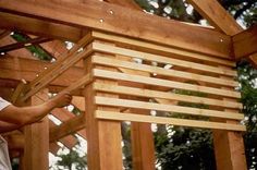 a man working on a wooden structure in the woods with wood beams and slats