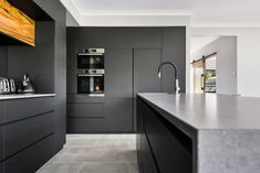 a modern kitchen with black cabinets and counter tops