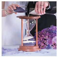 the bride and groom are pouring sand into their hourglasses