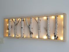 lighted birch trees are mounted on the wall