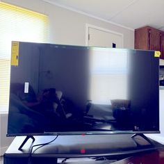 a flat screen tv sitting on top of a wooden table