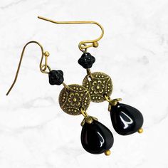 Long black beaded earrings in brass. Richly detailed brass finish Mandala connectors suspend Czech glass teardrop beads. Perfect long dangle earrings to go with everything from jeans to dress up. These Bohemian earrings are a wardrobe must-have! Hypoallergenic ear wires (nickel and lead free). Choose ear wires at checkout.  Artisan glass beads produced in small quantities in the Czech Republic. A gift for you or someone special, earrings are carded and in an organza bag. Available in ANTIQUE COP Black Bohemian Teardrop Dangle Earrings, Nickel-free Brass Beaded Teardrop Earrings, Nickel-free Teardrop Beaded Brass Earrings, Nickel-free Brass Teardrop Beaded Earrings, Elegant Adjustable Brass Beaded Earrings, Elegant Black Czech Glass Earrings, Teardrop Brass Beaded Earrings With Ear Wire, Black Bohemian Teardrop Earrings For Gift, Black Bohemian Teardrop Earrings As Gift