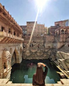 a woman is looking at the water in an old city