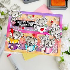 a card with some stickers on it next to flowers and pens, scissors and markers