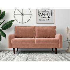 a living room with a couch, clock and plant on the wall in front of it