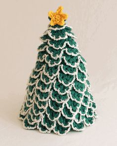 a crocheted christmas tree with a star on top, sitting in front of a white background