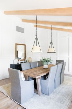 a dining room table surrounded by chairs and lights