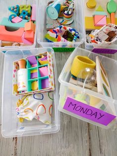 four plastic containers filled with toys on top of a wooden floor