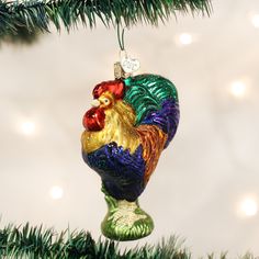 a glass ornament shaped like a rooster on top of a christmas tree branch